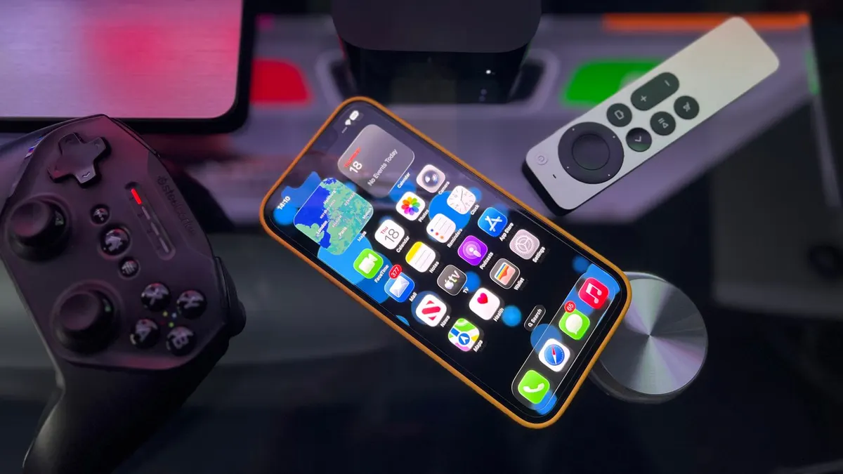 Apple TV, iPhone ja peliohjain tummalla alustalla.