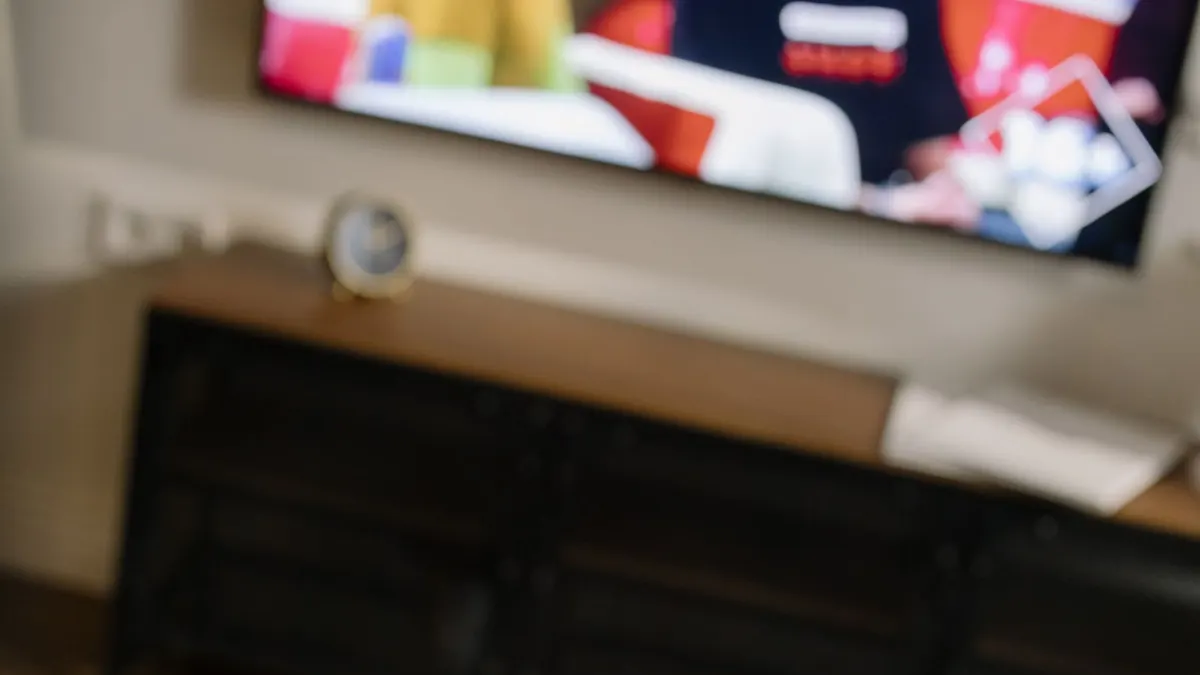 Television katselua sohvalta kaukosäätimen avulla.